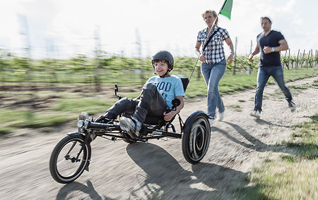 Sammy's parents chase behind him as he rides the Hase Trix recumbent trike