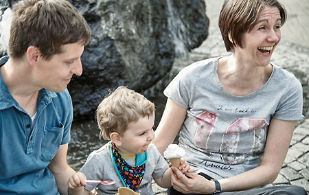 Smiling man, woman and child eating an ice cream cone
