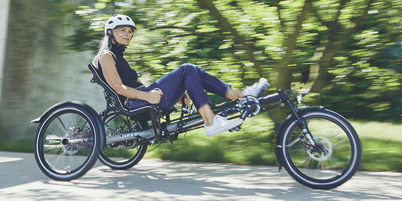 Smiling woman riding a Kettwiesel Evolution recumbent trike