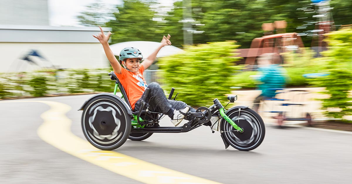 Picture of a boy riding a Hase TRETS recumbent trike for kids