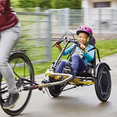 Child riding the Trets Reh recumbent trike as a trailer