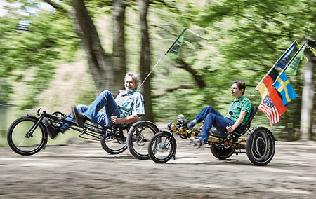 Father and son riding their tandem linked adaptive recumbent trikes
