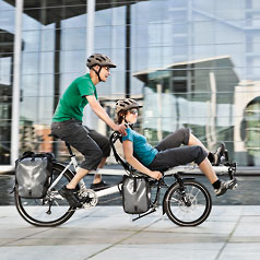 Man and woman riding a Tandem Pino Allround in a city