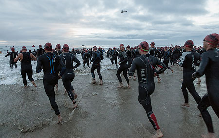 Triathlon athletes running into the water