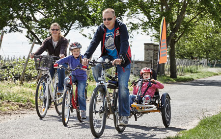 Family bike ride with a child in a Trets Reh recumbent trike used as a trailer